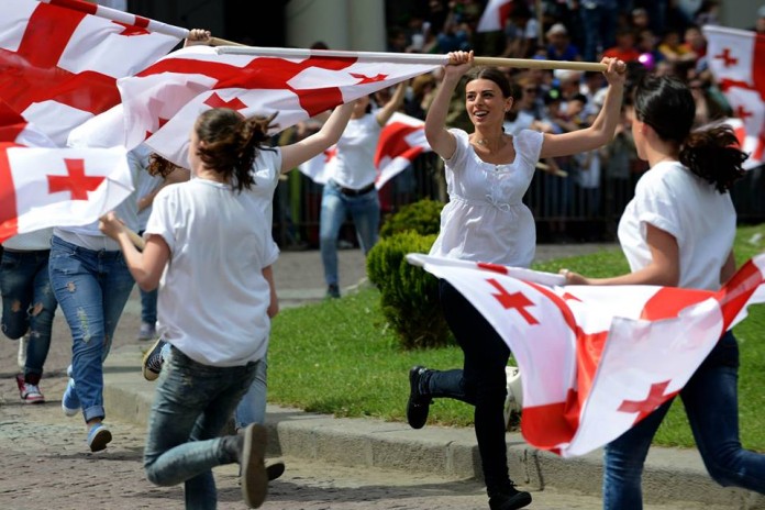 Celebracions durant el Dia de la Independència del 26 de maig de 2014. El 26 de maig de 1918 es creava la República Democràtica de Geòrgia. La bandera de les Cinc Creus Vermelles (en georgià: ხუთჯვრიანი დროშა) va ser adoptada el 2004.
