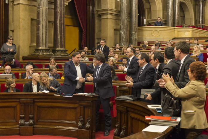 El president de la Generalitat, Carles Puigdemont, i el vicepresident, Oriol Junqueras, encaixen les mans després de la votació Parlament de Catalunya (Job Vermeulen). 2016