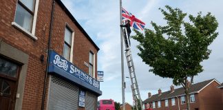 Dos homes pengen la bandera britànica a un barri unionista de l’est de Belfast. Les setmanes prèvies a la marxa Orange del 12 de juliol, es multiplica la simbologia nacional (i també la sectària). / Alfons Cabrera